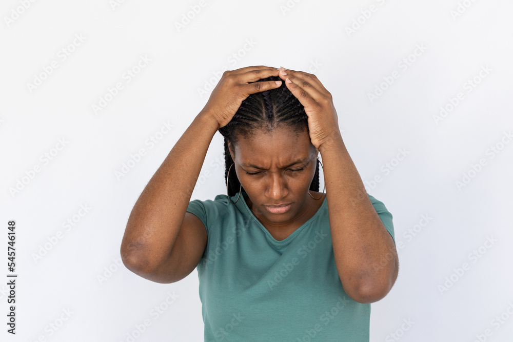 Sad woman holding head. Young female model in turquoise T-shirt experiencing headache. Portrait, studio shot, health concept Sad woman holding head. Young female model in turquoise T-shirt experiencing headache. Portrait, studio shot, health concept