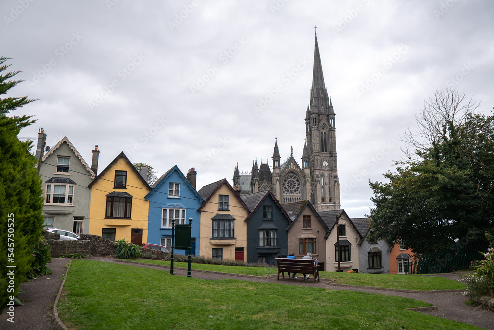 Colorful row of houses with towering cathedral in background in the port town of Cobh, County Cork, Ireland