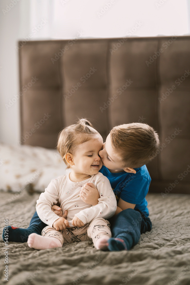 Adorable little boy is hugging and kissing his baby sister. Adorable little boy is hugging and kissing his baby sister.