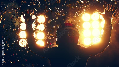 Silhouette of race car driver celebrating the win in a race against bright stadium lights. 100 FPS slow motion shot