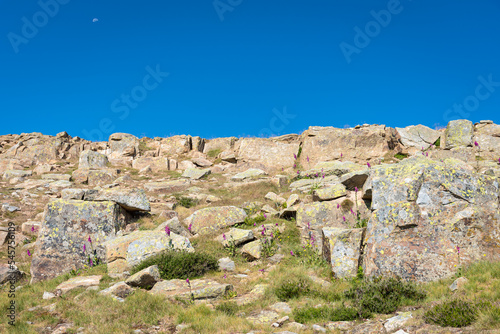 Rocks on the slope of a mountain in Neila lagoons natural park with clouds below the peaks in the background in morning daylight, Neila, Burgos, Spain