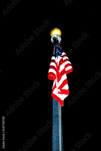 American flag at night high in the sky outdoors.