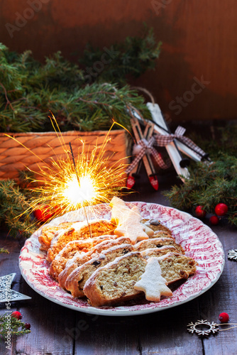 Obraz na płótnie Christmas stollen with dried fruits, nuts and spices, Christmas decorations on a dark wooden background. Rustic style. w salonie