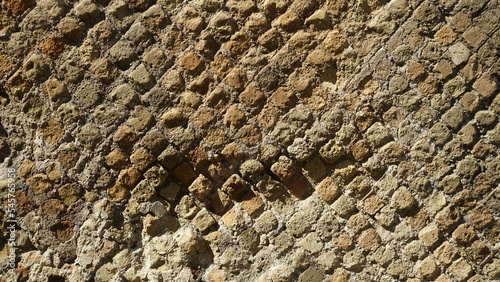 Fotografia Detail of a wall in a Roman structure built with the opus reticulatum technique in blocks of porphyry, in the archaeological site of Ostia Antica