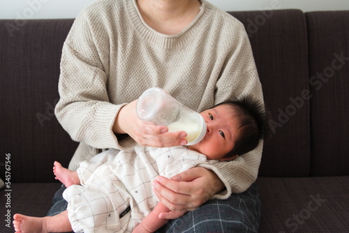 産後1か月0歳の新生児にミルクをあげている様子を正面から撮影した写真 photo