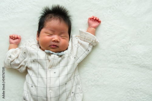 寝ている産後1か月0歳の新生児の腰から上の左寄りの俯瞰写真 photo