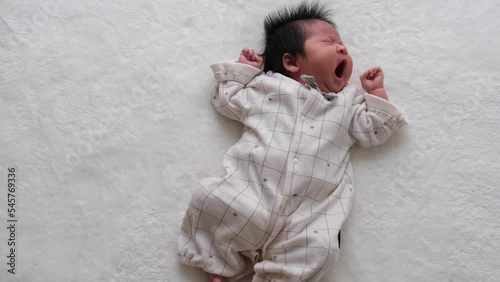 産後1か月0歳の新生児が寝ながらあくびしている全身を撮影した動画 photo