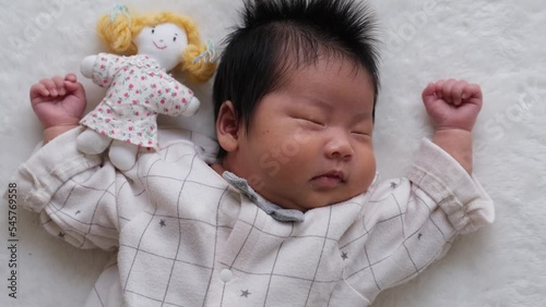 産後1か月0歳の新生児が女の子の人形と一緒に寝ている動画 photo