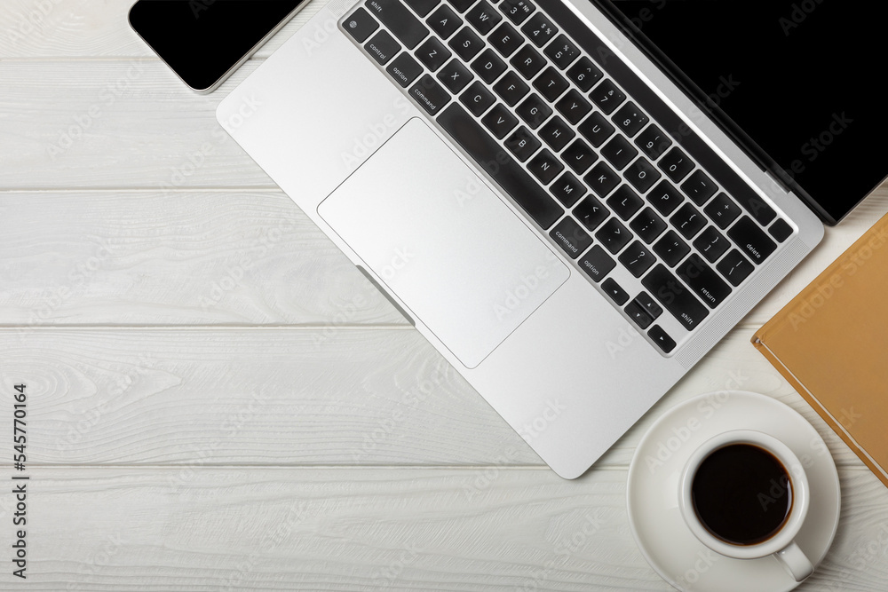Modern workspace. Laptop with coffee cup and smartphone. Copy space mockup on white texture background. View from above. Flat style. Modern workspace. Laptop with coffee cup and smartphone. Copy space mockup on white texture background. View from above. Flat style.