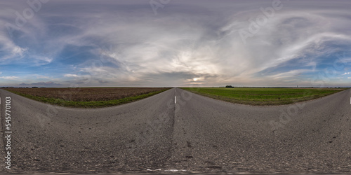 full seamless spherical hdri 360 panorama view on no traffic asphault road among fields with evening sky and clouds in equirectangular projection can be used as replacement for sky in panoramas