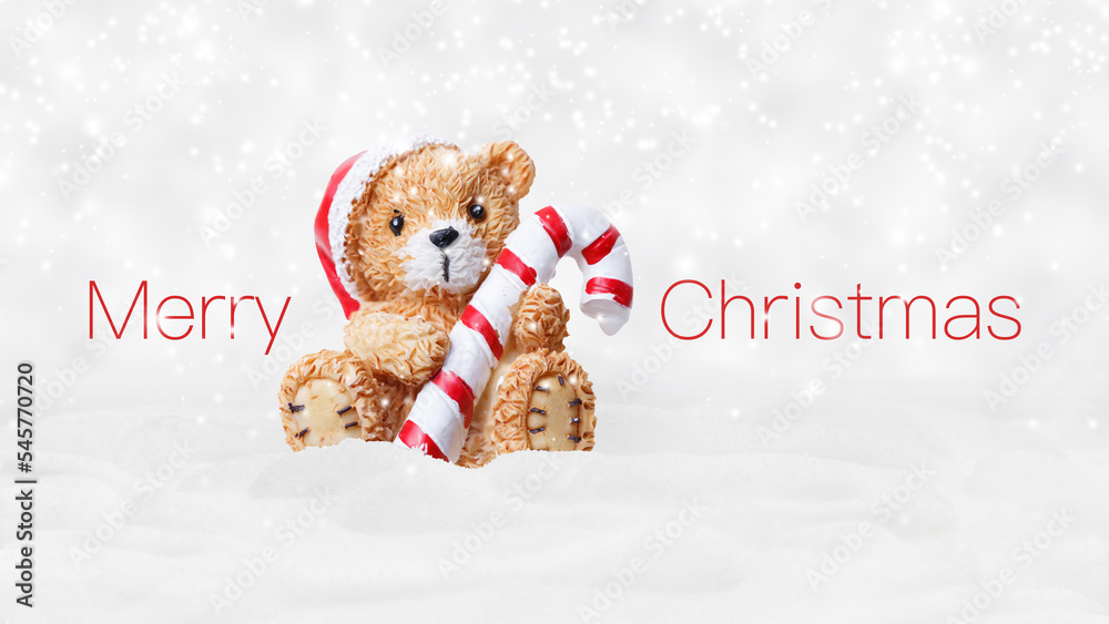 Merry Christmas text and teddy bear with red hat and candy striped cane stick isolated on snowing background, white Christmas concept template for greeting gift card or promotion advertising banner Merry Christmas text and teddy bear with red hat and candy striped cane stick isolated on snowing background, white Christmas concept template for greeting gift card or promotion advertising banner