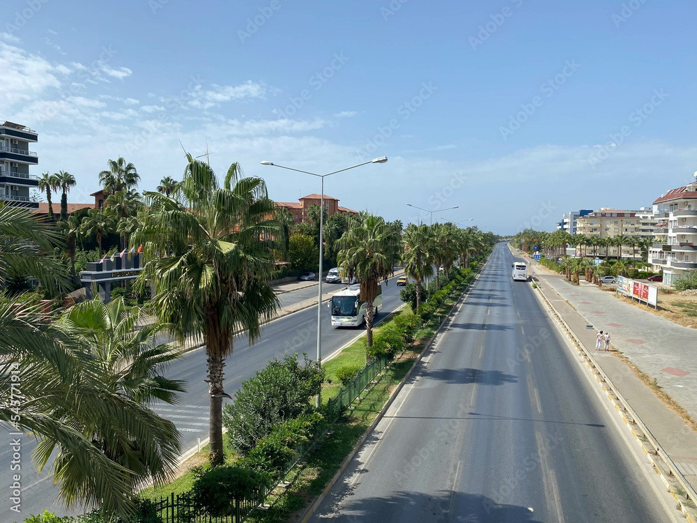 Large wide multi-lane highway road with palm trees on the sides in a warm tropical country southern resort