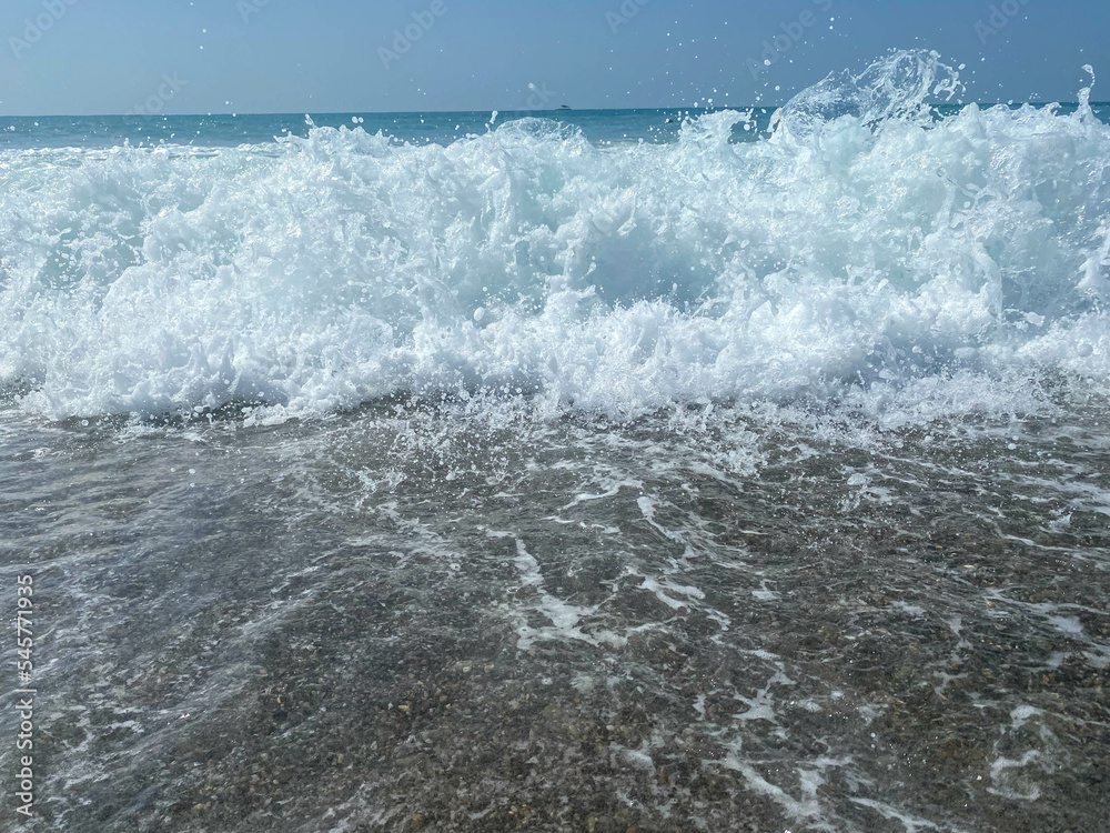Beautiful sea with waves splashing warm sparkling clear blue water in a warm tropical oriental country southern resort. Background, texture