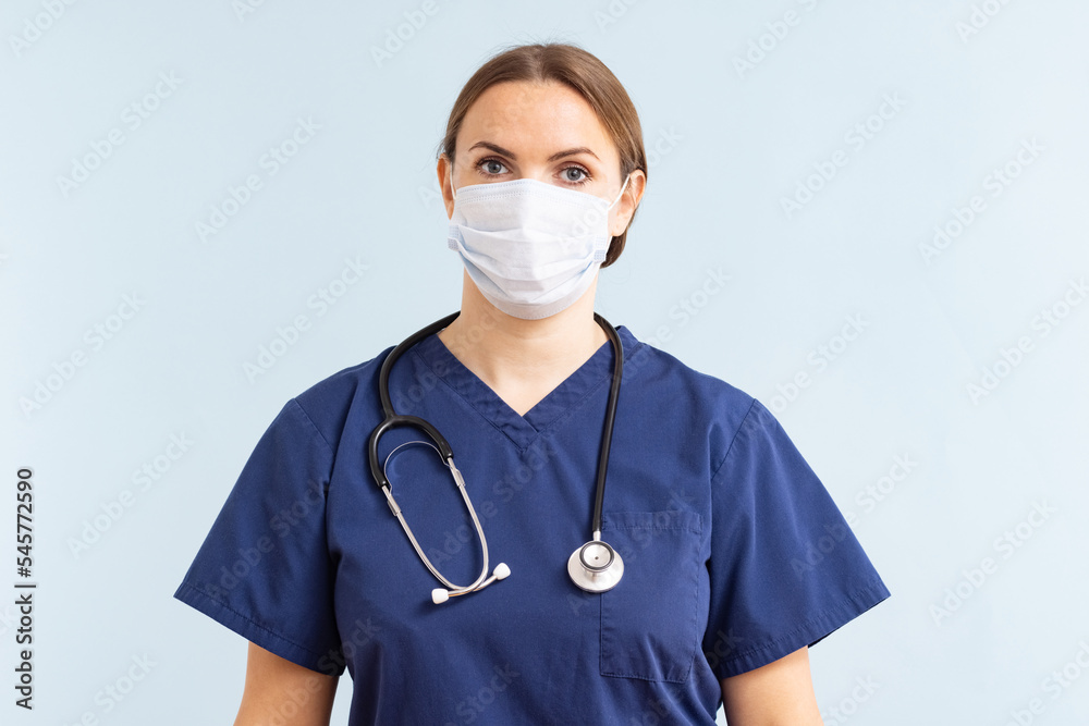 Female doctor in medical mask with stethoscope on a blue background Female doctor in medical mask with stethoscope on a blue background