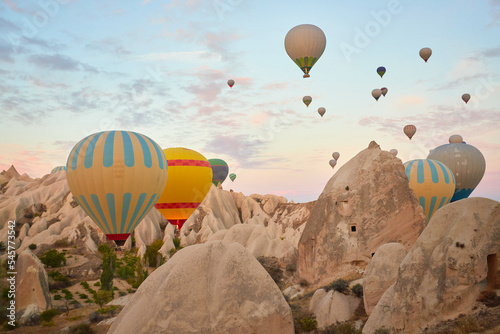 Hot air balloons flying in sunset sky Cappadocia, Goreme, Turkey. Great tourist attraction - sunrise balloning over Cappadocia valleys