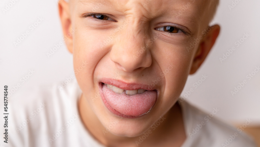 Close-up smile of a little happy child of 8 years old who shows the tongue Close-up smile of a little happy child of 8 years old who shows the tongue