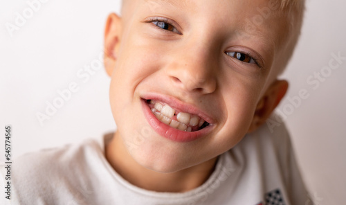 Portrait of young happy child smiling and laughing cheerful wearing hite t-shirt isolated on white background in kid happiness and joyful face expression concept