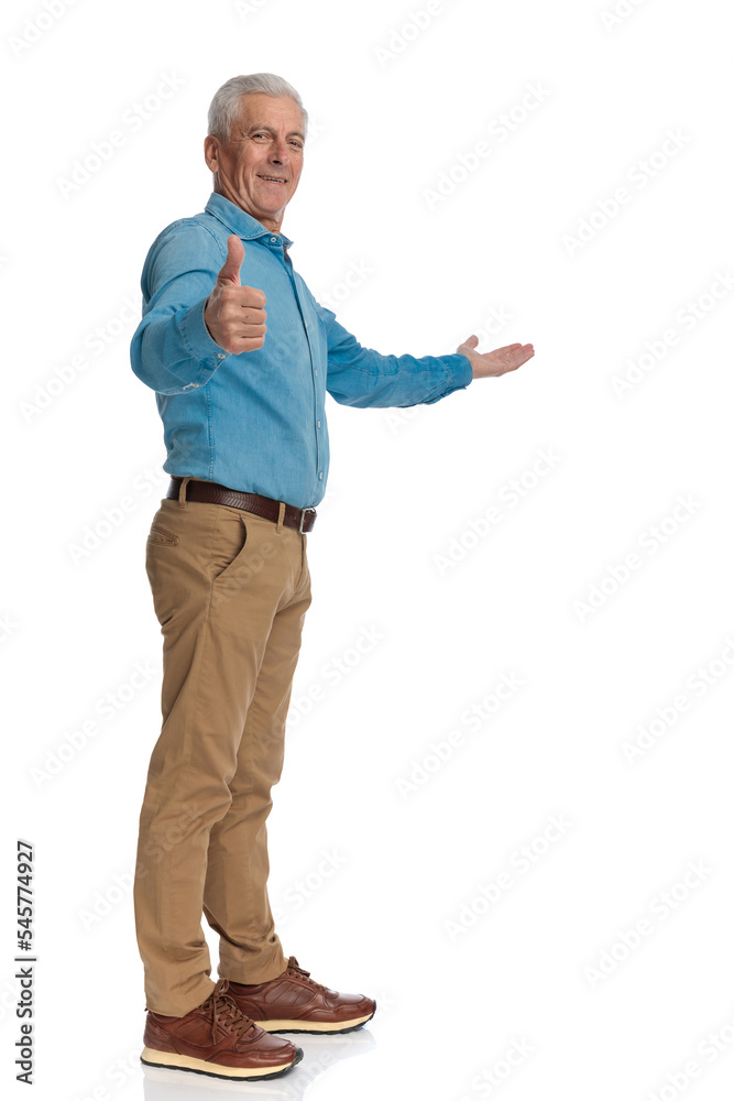 casual man with grey hair standing in line, inviting to side and smiling casual man with grey hair standing in line, inviting to side and smiling