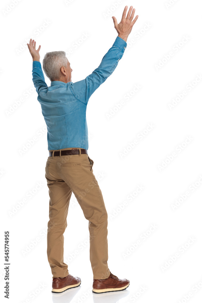 excited man in casual shirt holding arms above head and celebrating excited man in casual shirt holding arms above head and celebrating