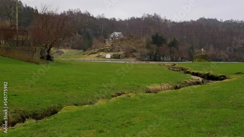 grass in norway with stream on cloudy day photo