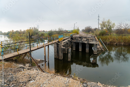 Destroyed bridge across the river. War in Ukraine. Russian invasion of Ukraine. Destruction of infrastructure. Terror of the civilian population. War crimes