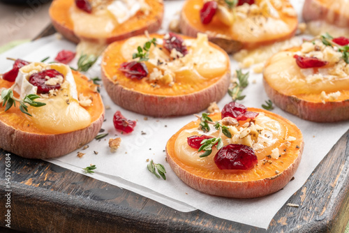 Fotografering Baked Sweet Potato Rounds topped with brie cheese, cranberry and Walnut