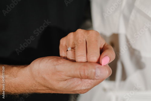 Man in love putting an engagement ring on woman finger. Propose. Closeup hands. Offer of hand and heart. Man holding his girl's hand - Man making a marriage proposal to his girlfriend. Engaged couple.
