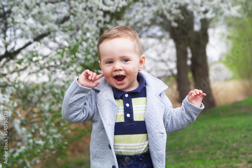 Beautiful cheerful child on the background of spring flowering