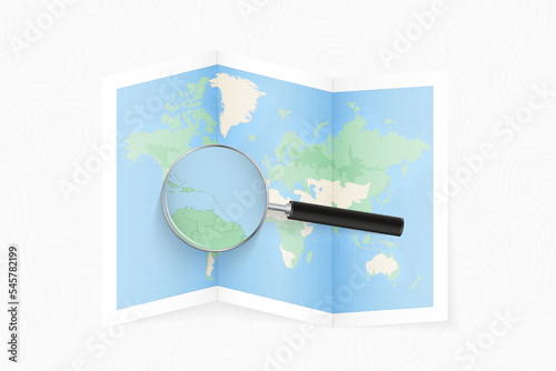 Enlarge Saint Vincent and the Grenadines with a magnifying glass on a folded map of the world.