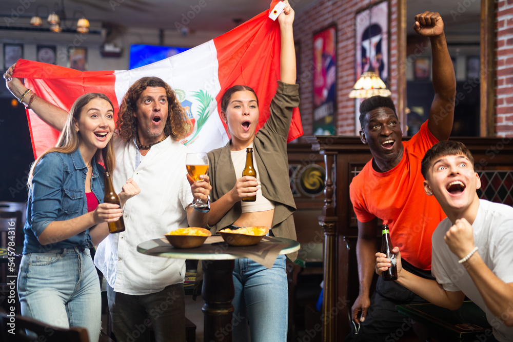 Happy friends celebrating the victory of the Peruvian team in a beer bar