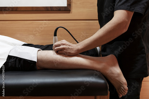 Ultrasound treatment applied in a massage room on the leg of a male client
