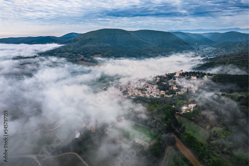 Panoramic view of the old village of Mirmande in France. Aerial photo in the morning in the thick fog rising around the town