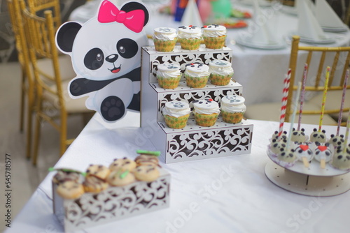Black and white cakes on the buffet stand in front of the decoration decorated with filling