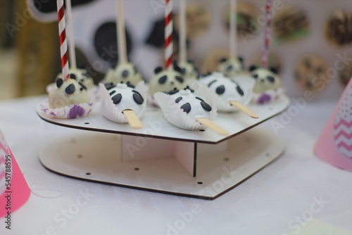 Black and white cakes on the buffet stand in front of the decoration decorated with filling