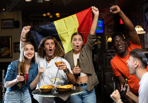 Happy fans celebrating the victory of Belgian team in the bar