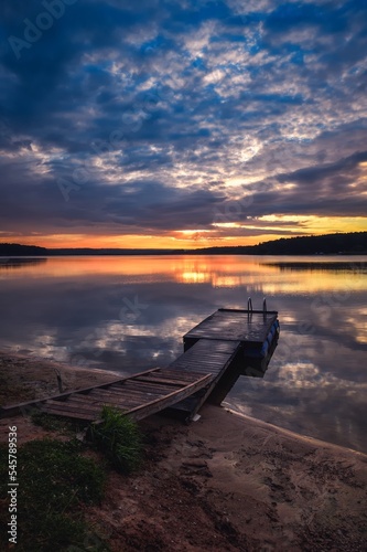 Sunrise on the lake. Wooden small pier in the morning scenery.