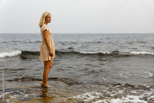 Stylish young woman walking by the sea, the concept of a healthy lifestyle © Enigma