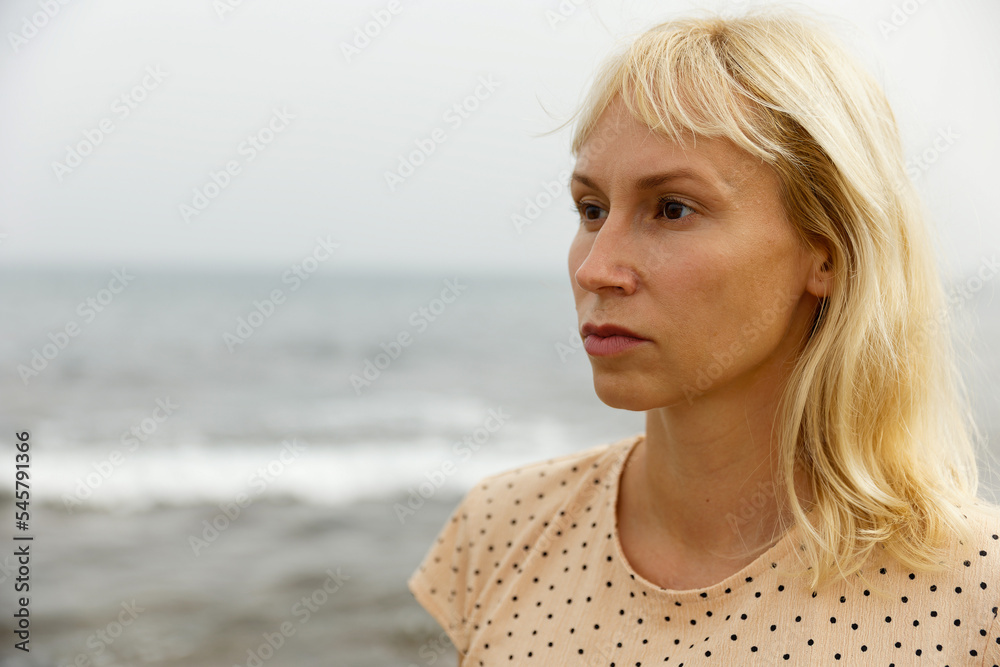 Portrait of a young pretty woman against the background of the sea