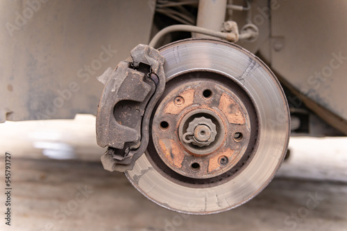 Heavily worn brake disc. Car brake disc after removing the wheel. A rusty disk that needs to be replaced.