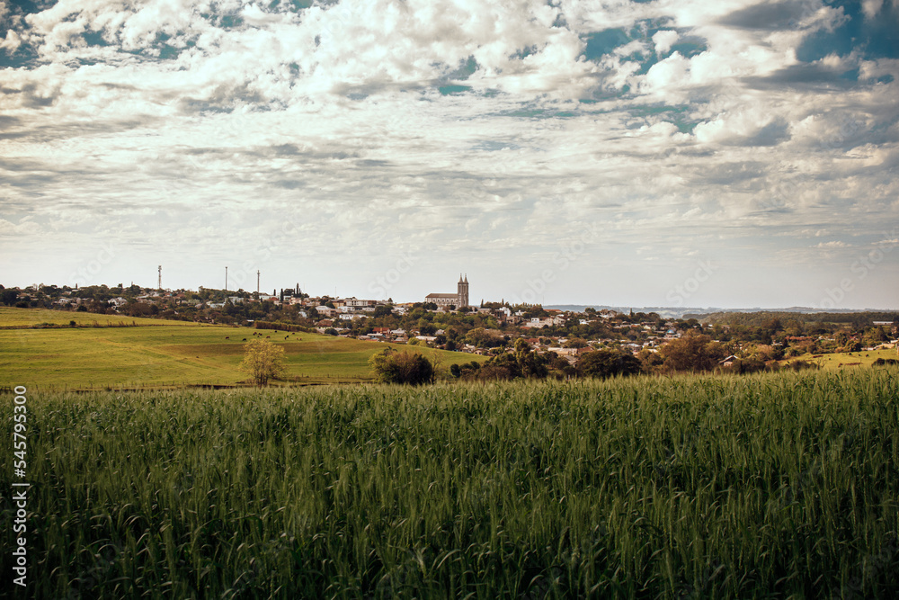 Vista da cidade de Santo Cristo, pequena cidade no interior do Rio Grande do Sul, campos, potreiros e plantações. Céu com nuvens