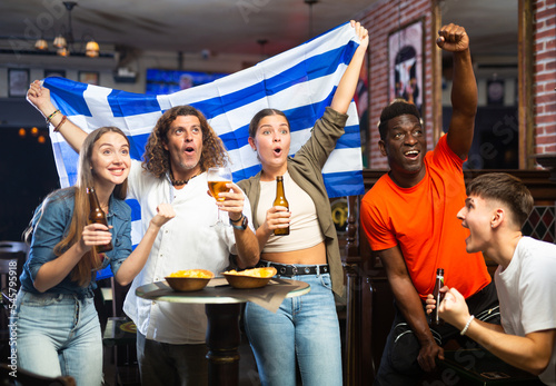 Enthusiastic Greek fans scream with joy in a beer bar. Greece win