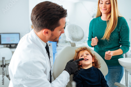 Orthodontist examining child in office.