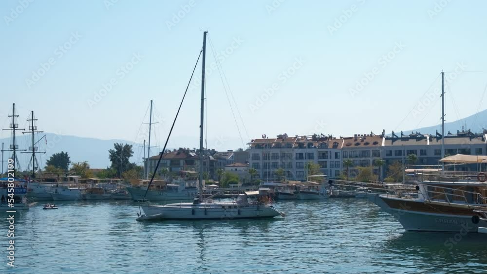 Luxury tourism yacht stop in bay. A view of luxury tourist trip on the sailing boat by the shore. A concept of summer sailing hobby in the sea. Luxury tourism yacht stop in bay. A view of luxury tourist trip on the sailing boat by the shore. A concept of summer sailing hobby in the sea.