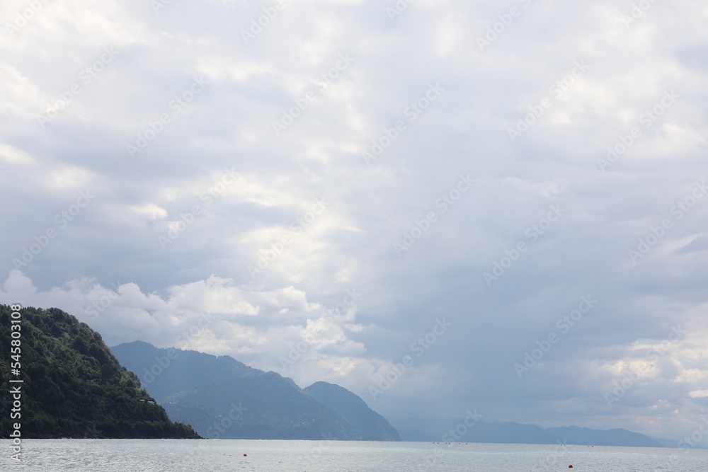 Fototapeta premium Picturesque view of beautiful sea and hills under sky with fluffy clouds