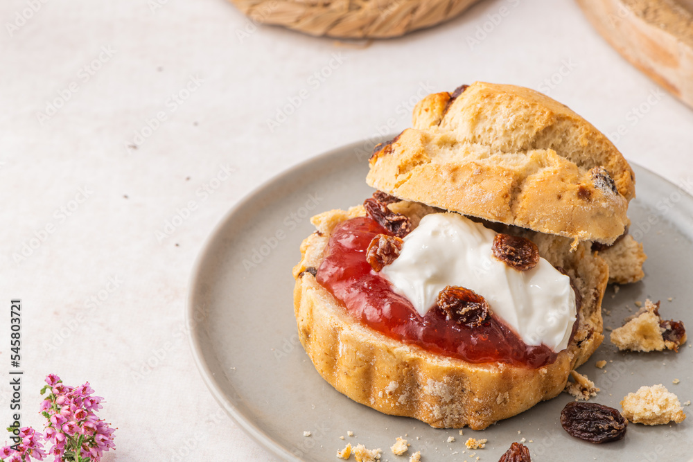 Homemade raisin scones with clotted cream and strawberry jam ready to eat Homemade raisin scones with clotted cream and strawberry jam ready to eat