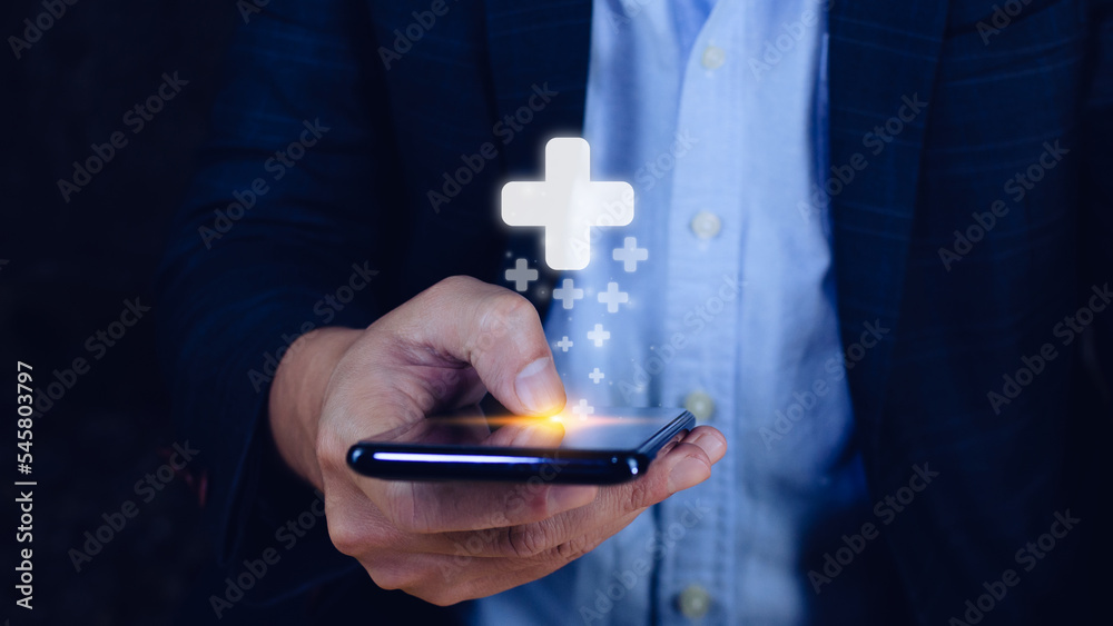 Businessman Hand holding smartphone in hand offer positive thing such as profit, benefits, development, CSR represented by plus sign.The hand shows the plus sign.