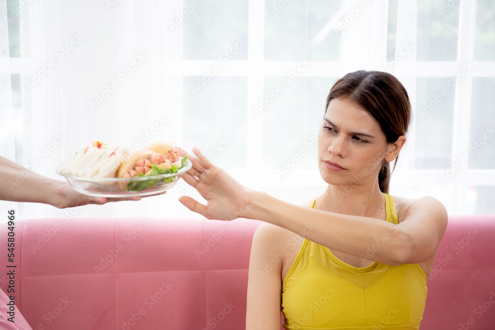 Hands serving food and young caucasian woman making sign say no food unhealthy with obese, woman refuse and push out food with temptation for dieting, nutrition and fast food a bad, health concepts. Hands serving food and young caucasian woman making sign say no food unhealthy with obese, woman refuse and push out food with temptation for dieting, nutrition and fast food a bad, health concepts.