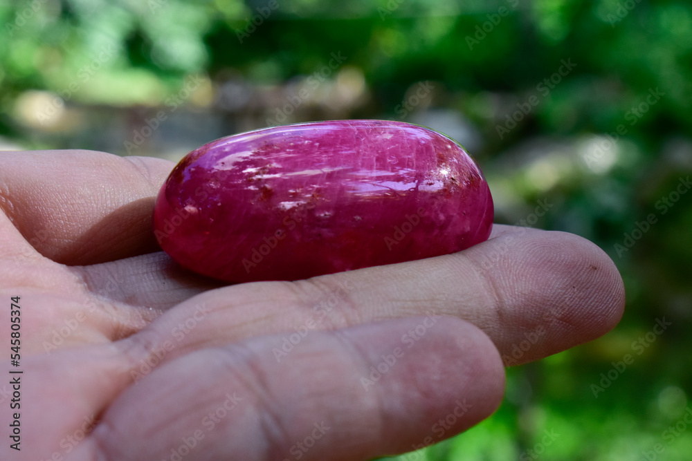 A large ruby stone in the hand A large ruby stone in the hand