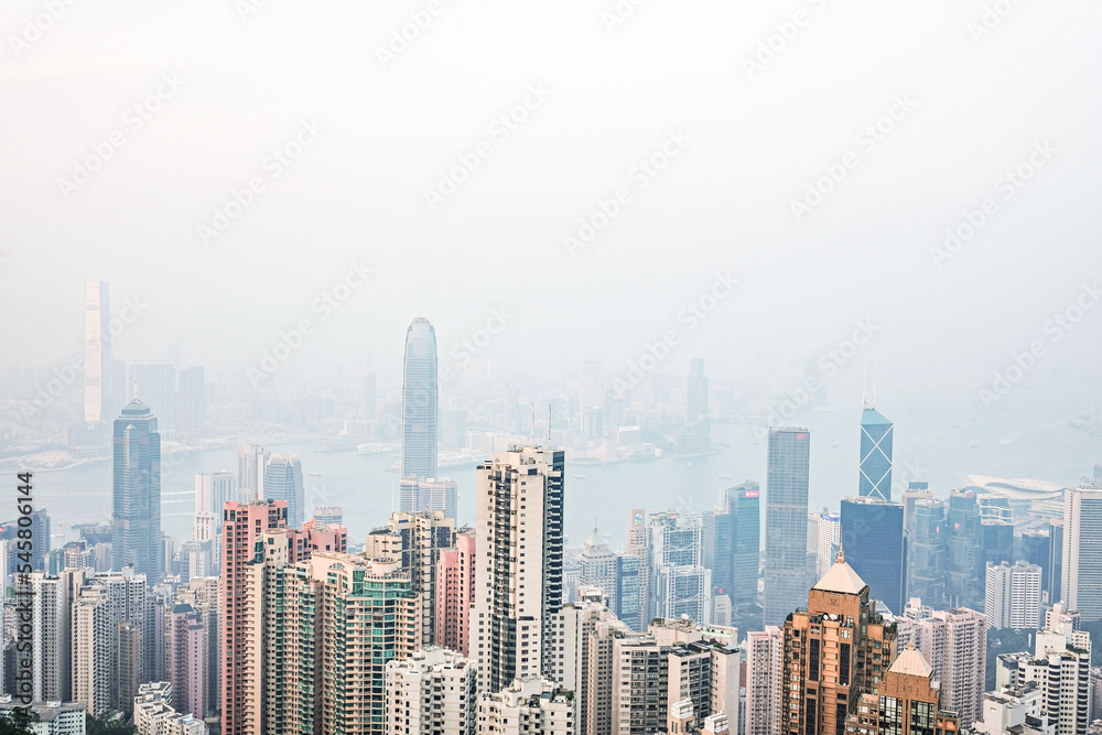 Aerial view of Victoria Harbour, Hong Kong skyline and parts of Tsim Tsa Tsui as seen from the Peak on a hazy day; Hong Kong Island, China