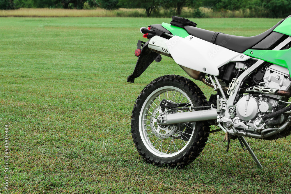 Fototapeta premium Stylish green cross motorcycle outdoors, space for text